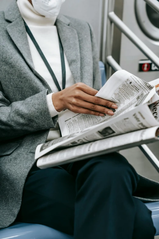 a man wearing a face mask while reading a newspaper, by Carey Morris, trending on unsplash, grey suit, underground, 15081959 21121991 01012000 4k, carrying a tray