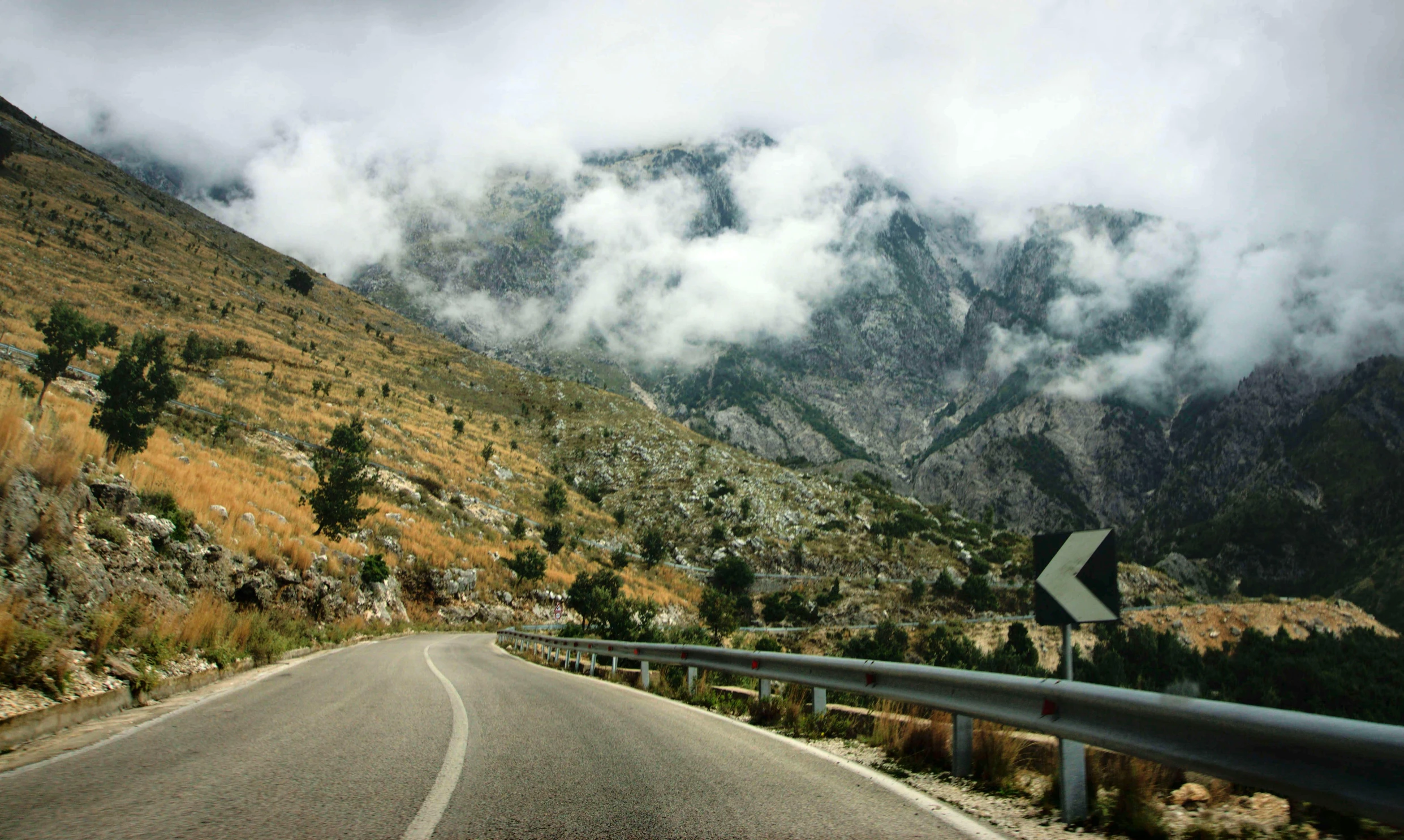 a car driving down a mountain road on a cloudy day, a picture, unsplash, les nabis, carrara marble, 2 0 0 0's photo, festivals, cyprus