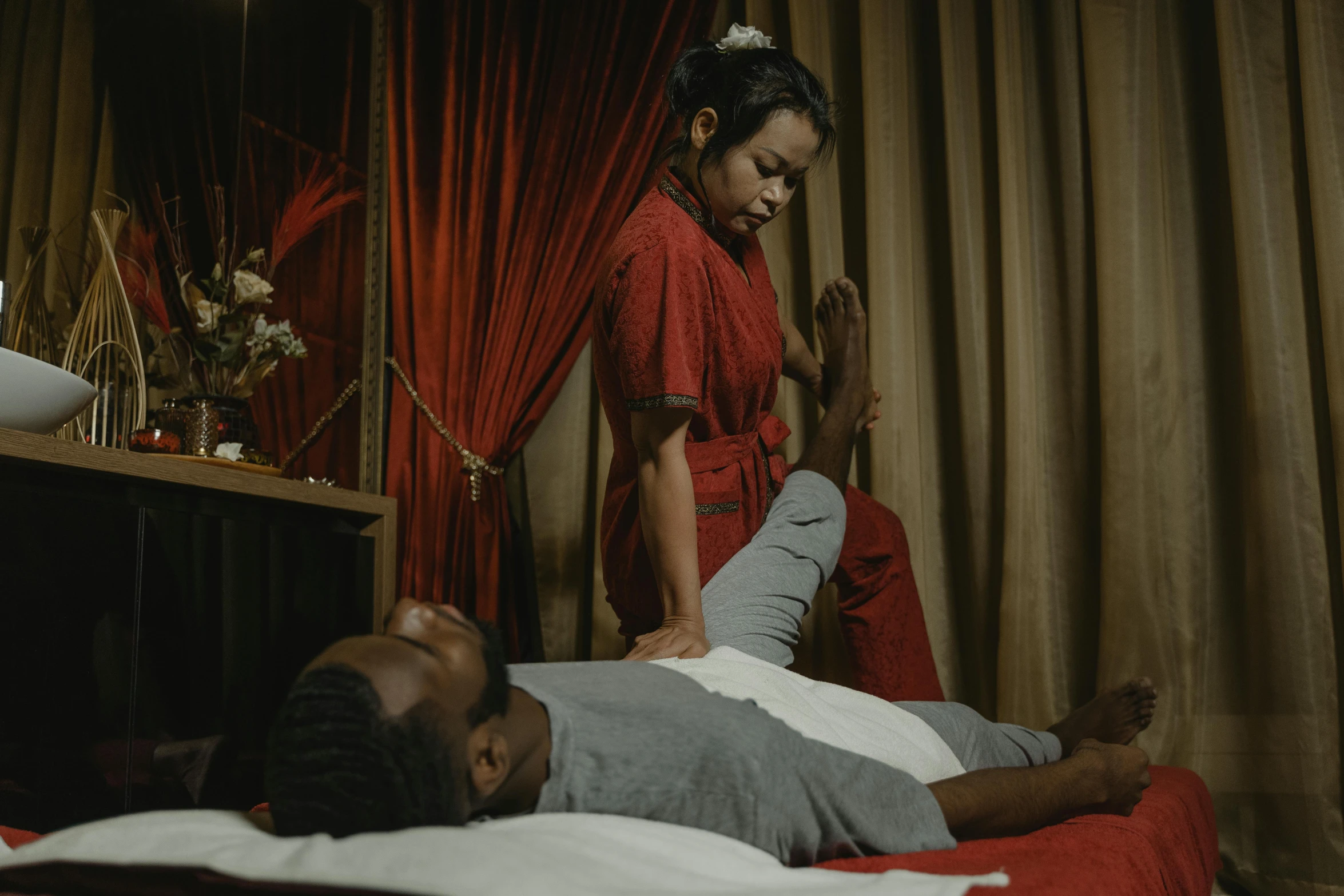 a man laying on top of a bed next to a woman, pexels contest winner, massurrealism, afro samurai style, against a red curtain, paradise garden massage, [ theatrical ]