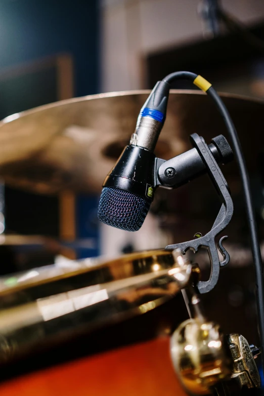a microphone sitting on top of a drum, an instrument, holding a microphone, up-close