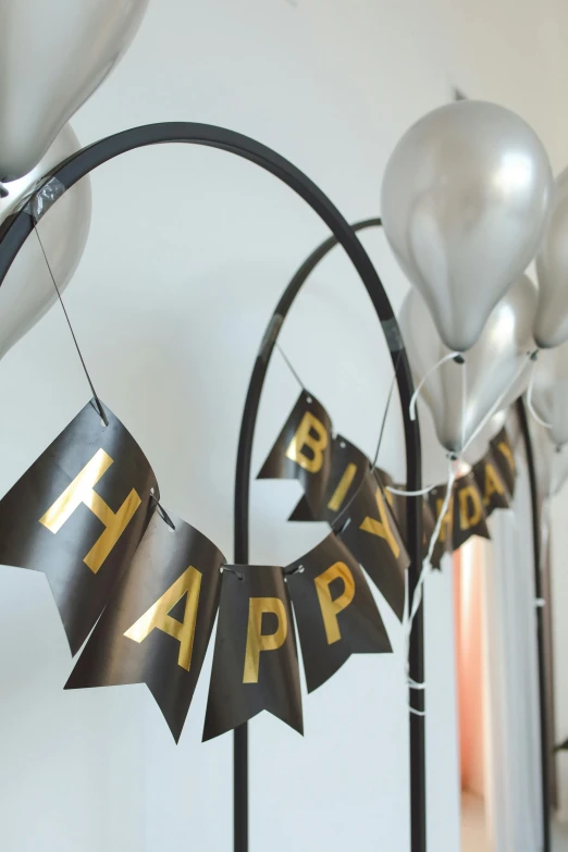 a bunch of balloons and a banner that says happy birthday, by Nina Hamnett, happening, in gunmetal grey, metalwork, medium close-up shot, curving black