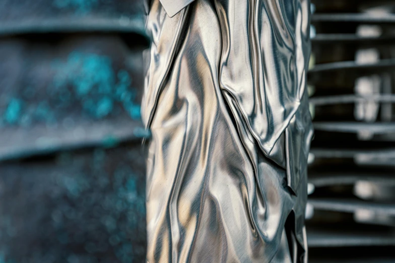 a close up of a silver umbrella on a pole, an abstract sculpture, inspired by Sir Jacob Epstein, unsplash, photorealism, metallic cyan bodysuit, wearing robes of silver, intricate wrinkles, flowing cloth and smoke