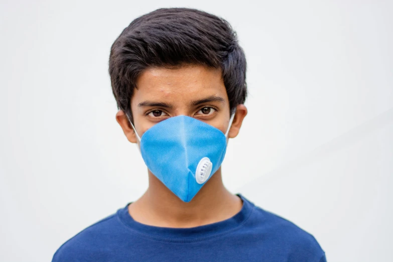 a young man wearing a blue face mask, pexels contest winner, hurufiyya, dezeen, teenage no, environmental, product introduction photo