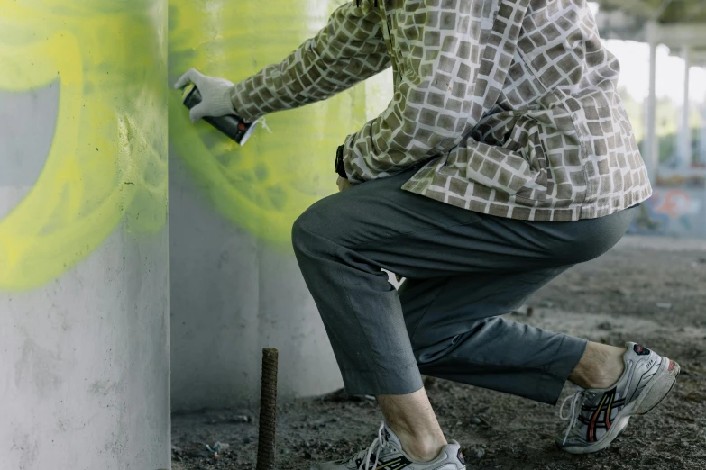 a man is painting graffiti on a wall, a hyperrealistic painting, inspired by Hans Hartung, unsplash, pants, dirty green clothes, grey, maintenance photo