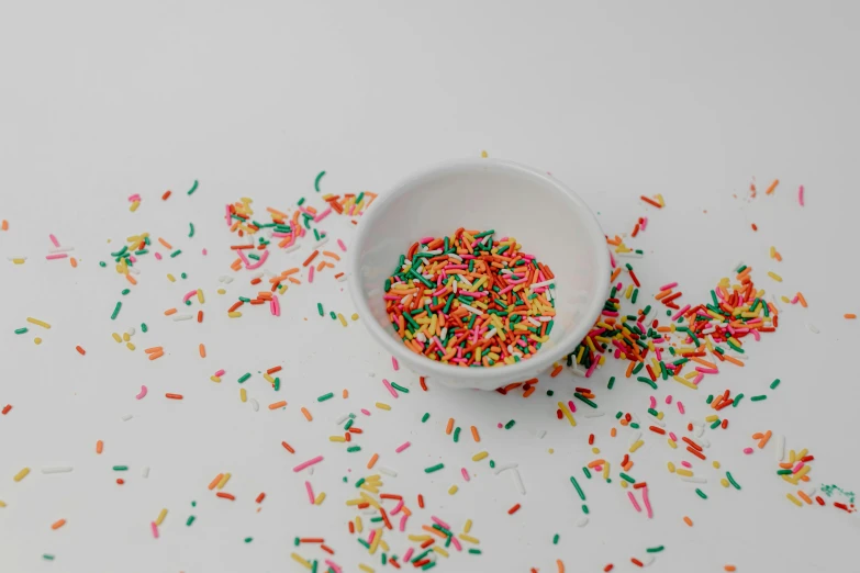 a bowl of sprinkles on a white surface, by Emma Andijewska, pexels, fan favorite, multicolor, miniatures, vanilla