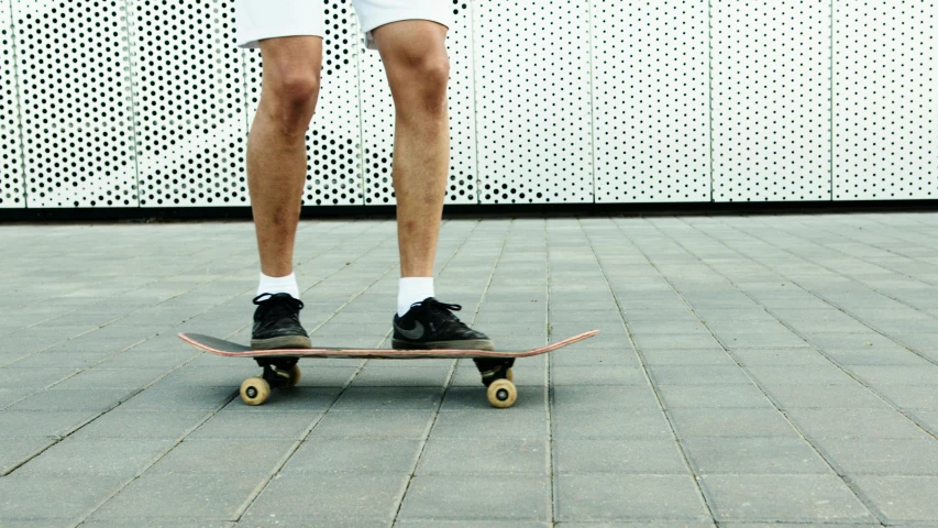 a man riding a skateboard down a sidewalk, unsplash, hyperrealism, thighs close up, on a hot australian day, plain background, 1 6 years old