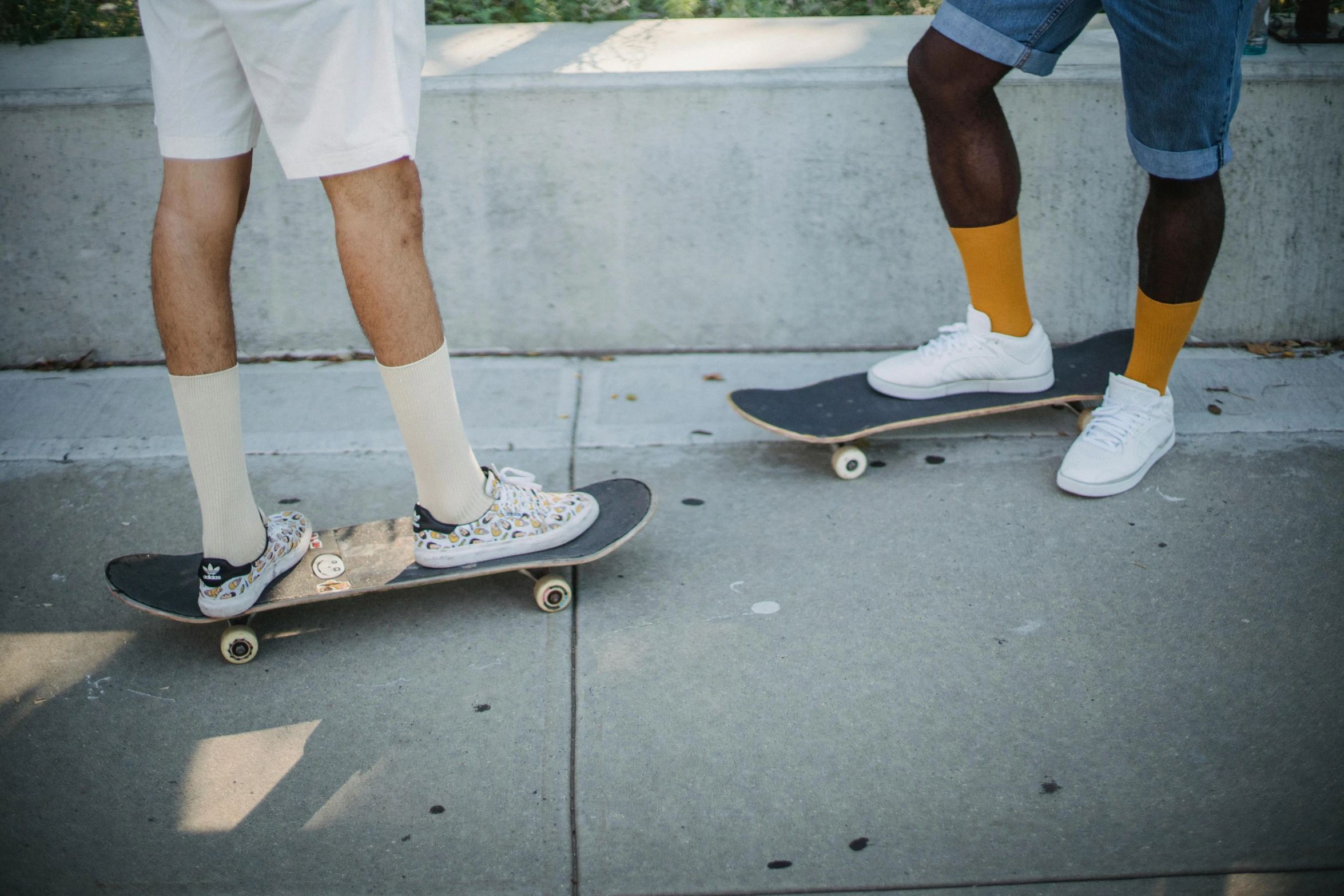 a couple of men standing next to each other on skateboards, trending on unsplash, gray shorts and black socks, college students, wearing white clothes, ignant