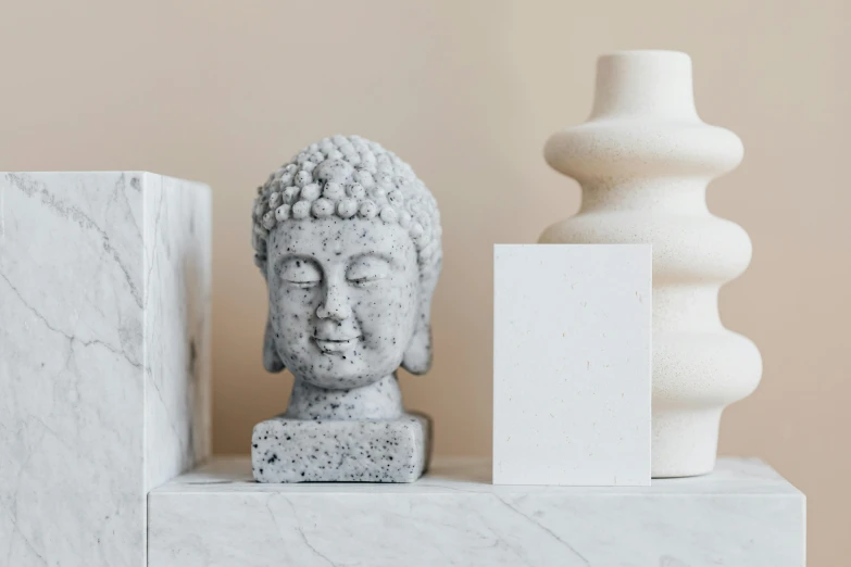 a close up of a statue of a person on a shelf, a marble sculpture, inspired by Kim Tschang Yeul, trending on pexels, concrete art, square face, the buddha, light source from the left, speckled