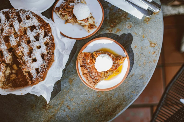 a table topped with plates of food covered in powdered sugar, by Daniel Lieske, trending on unsplash, renaissance, apple pie, lattice, slightly sunny, hollister ranch