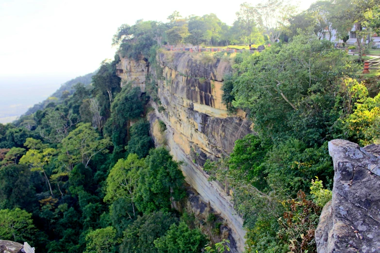 a group of people standing on top of a cliff, by Ella Guru, hurufiyya, as seen from the canopy, assamese aesthetic, sandstone, very long