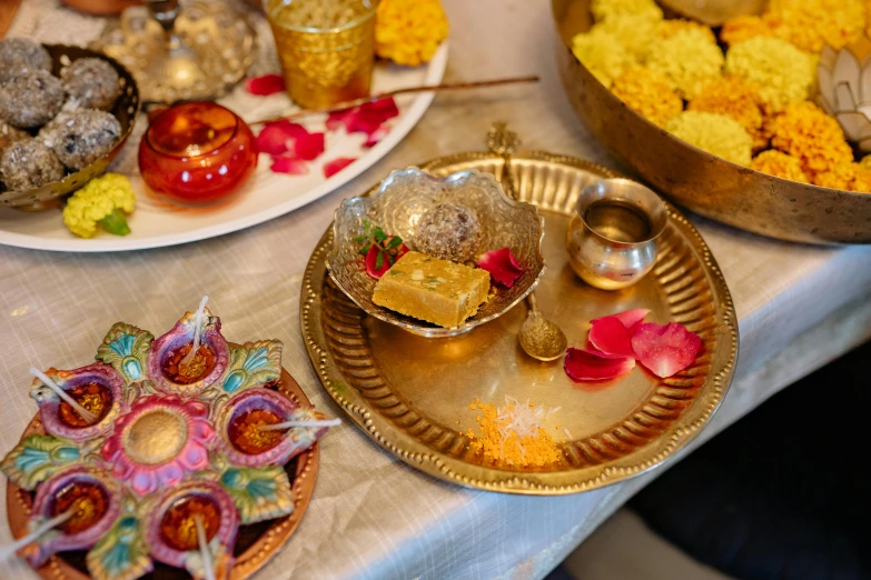 a close up of plates of food on a table, hindu ornaments, liquid gold, thumbnail, at home