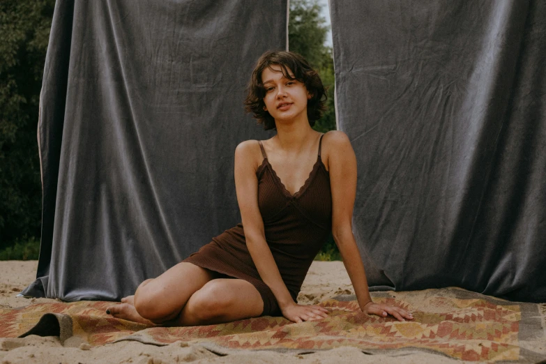 a woman in a brown dress sitting on a blanket, an album cover, by Attila Meszlenyi, pexels contest winner, wearing a camisole and shorts, irina french, lofi portrait, high quality photo