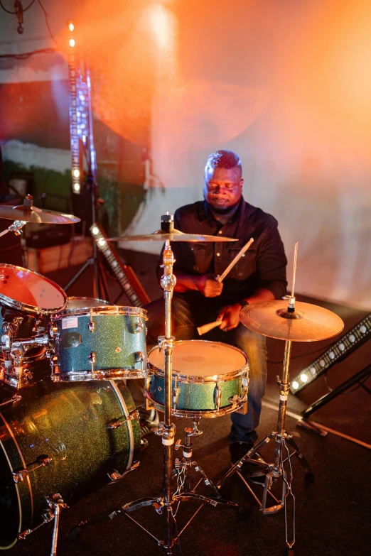 a man sitting in front of a drum set, profile image