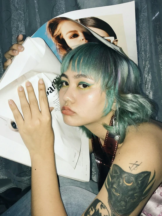 a woman with green hair holding a magazine, an album cover, inspired by Elsa Bleda, trending on pexels, asian women, with index finger, ☁🌪🌙👩🏾, hair whitebangs hair