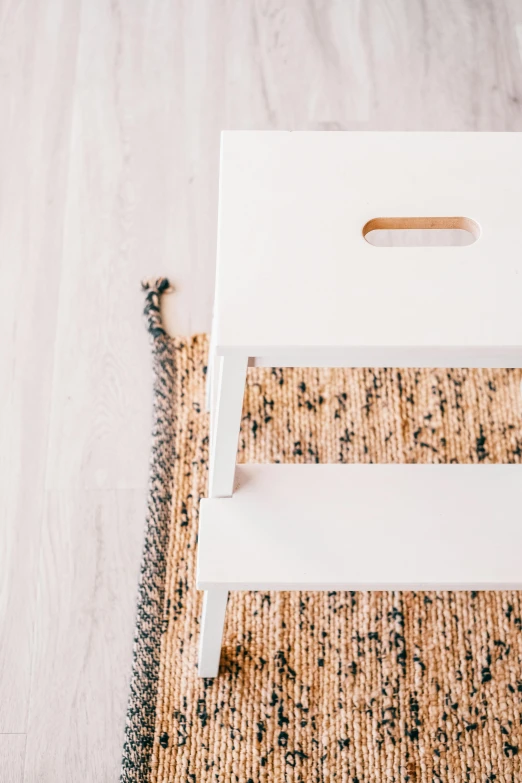 a white step stool sitting on top of a rug, by Julia Pishtar, trending on unsplash, hemp, one contrasting small feature, 1 6 x 1 6, ladder