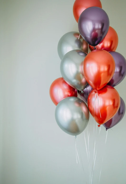 a bunch of balloons sitting on top of a table, payne's grey and venetian red, classic chrome, medium head to shoulder shot, deep purple and orange