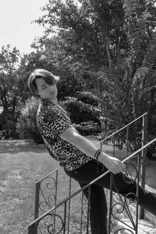 a black and white photo of a woman sitting on a railing, inspired by Jean Malouel, park jimin, portrait!!!, king of the jungle, - photorealistic