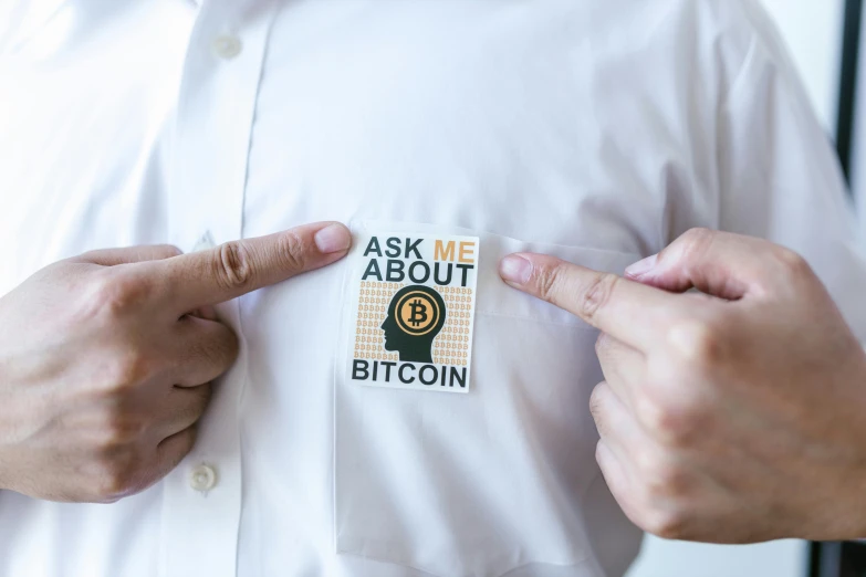 a man wearing a button that says ask me about bitcoin, by Julia Pishtar, white dress shirt, sticker sheet, teasing, thumbnail