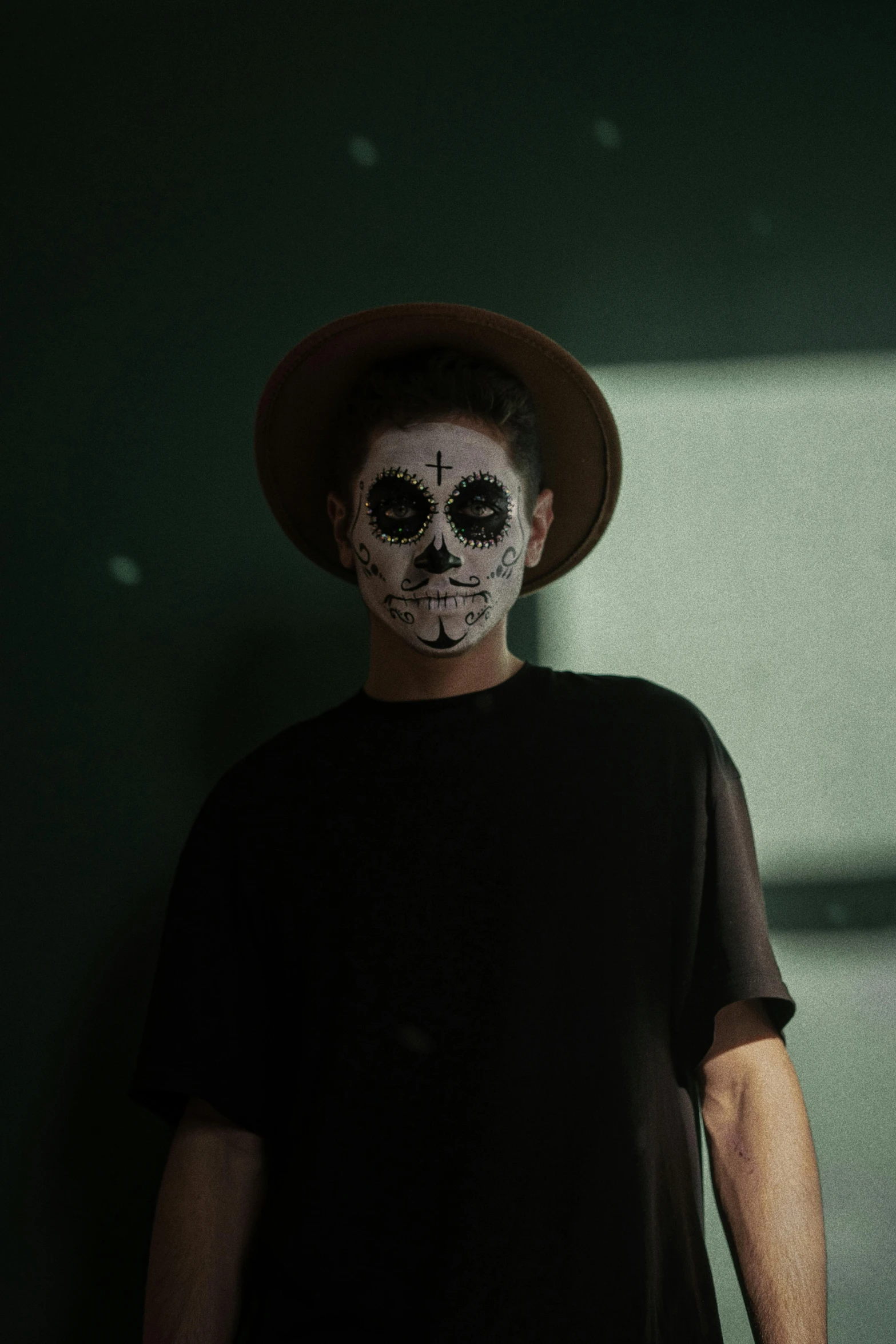 a man with a skeleton face painted on his face, by Byron Galvez, pexels contest winner, dark hat, more tan face, low quality photo, teenager