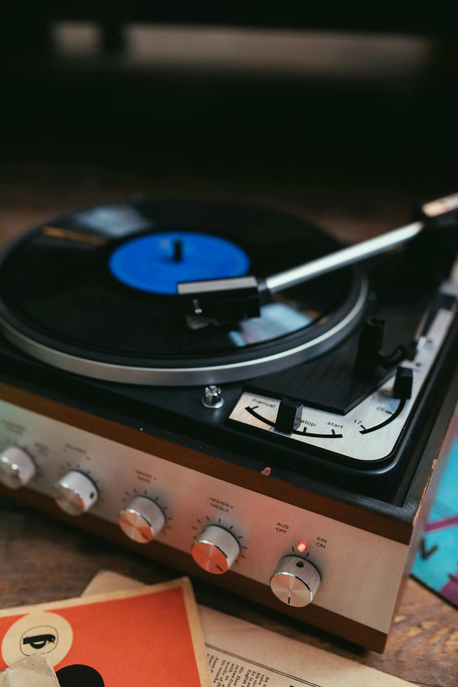 a record player sitting on top of a wooden table, during the night