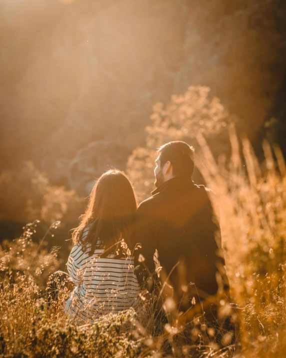 a couple sitting next to each other in a field, pexels contest winner, golden rays of sunlight, instagram post, autumn light, single