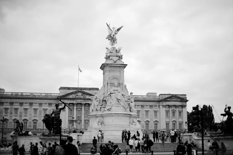 a black and white photo of a statue in front of a building, monarchy, people walking around, slight overcast weather, queen