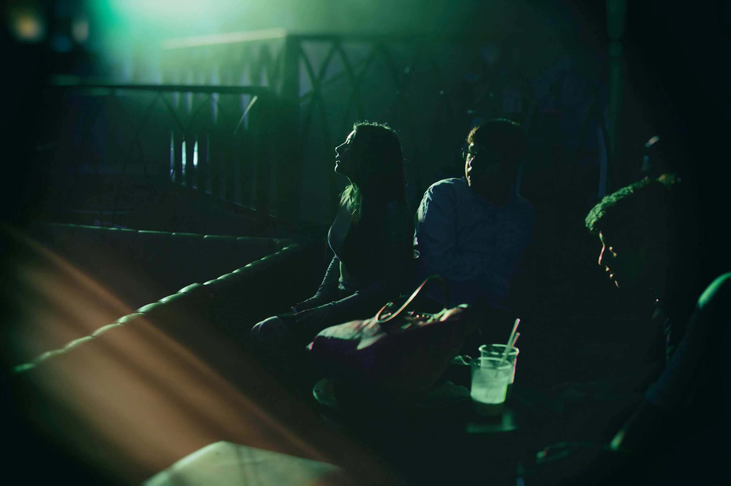 a group of people sitting next to each other, inspired by Elsa Bleda, green lights, horror footage, teenager hangout spot, worksafe. cinematic