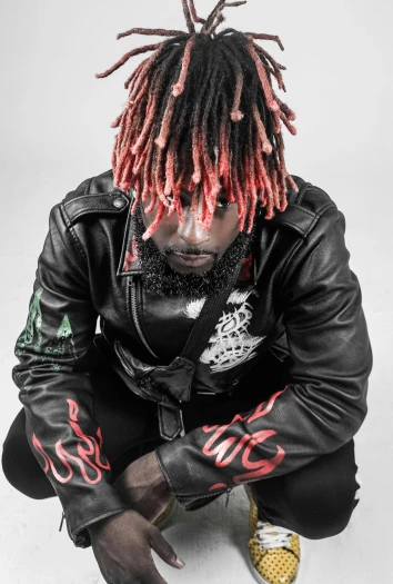 a man with dreadlocks sitting on the ground, an album cover, inspired by Cam Sykes, trending on pexels, black and red jacket, headshot profile picture, lil uzi vert, fire hair