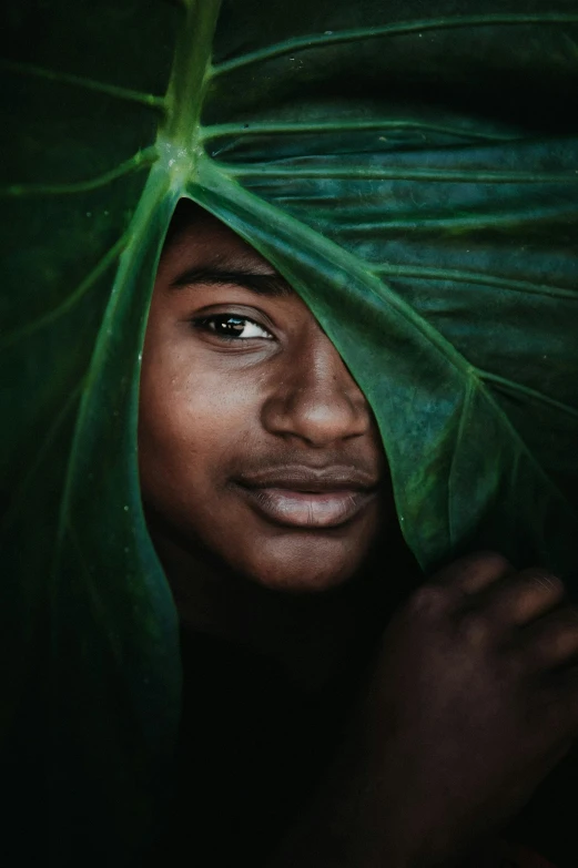 a close up of a person with a leaf on their head, a picture, unsplash contest winner, black teenage boy, lush greens, ignant, portrait 8 k