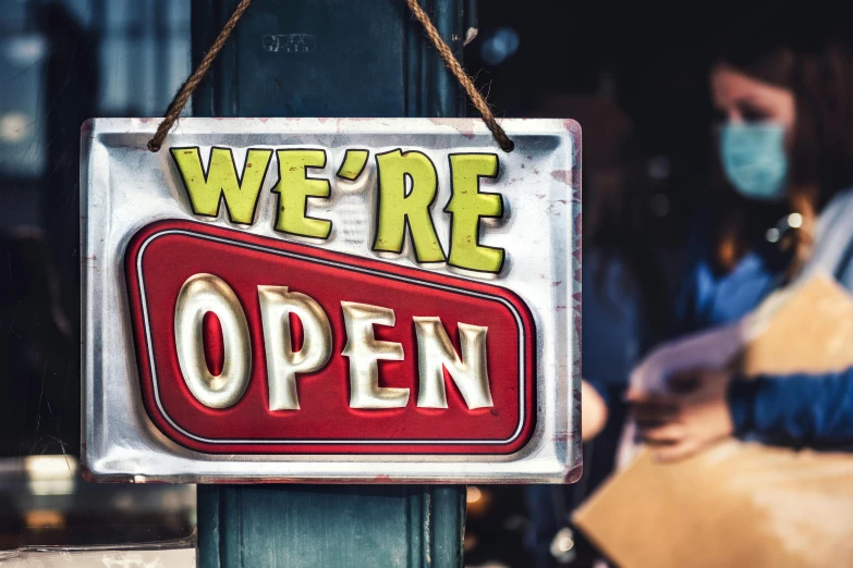 a sign that says we're open hanging on a pole, pexels, square, high detailed store, handheld, looking in front