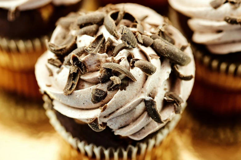 a close up of a cupcake with chocolate frosting and sprinkles, by Helen Stevenson, renaissance, thumbnail, grey, edible, cream