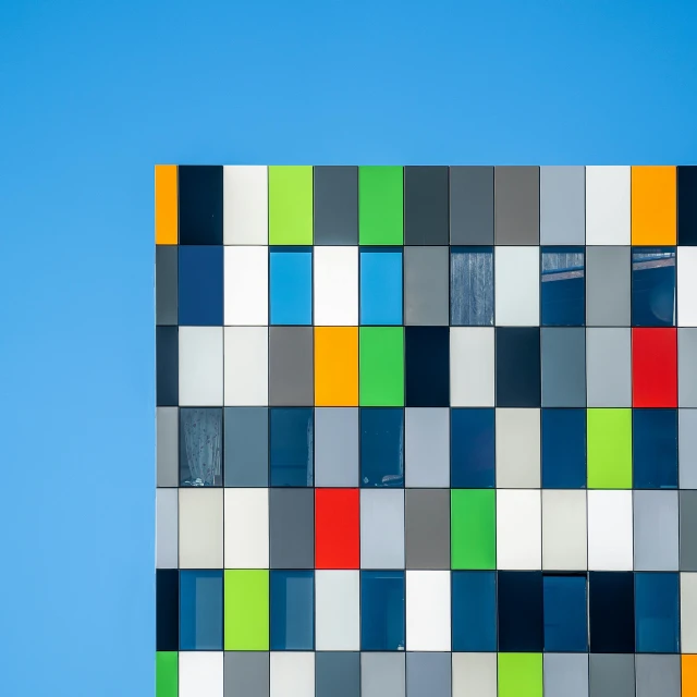 a multicolored building against a blue sky, pixel art, unsplash, de stijl, metal cladding wall, full frame image