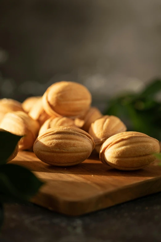 a pile of almonds sitting on top of a wooden cutting board, inspired by Károly Patkó, hurufiyya, macaron, lush surroundings, sycamore, individual