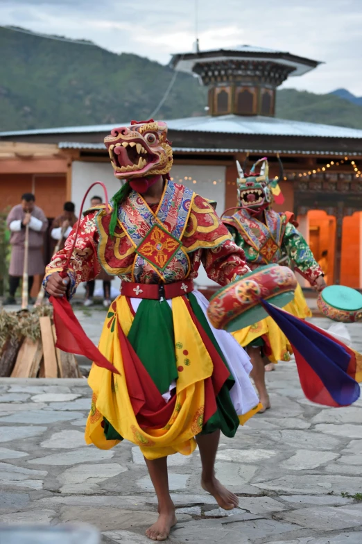 a group of people that are standing in the street, tibetan skeleton dancer, slide show, square, bhutan