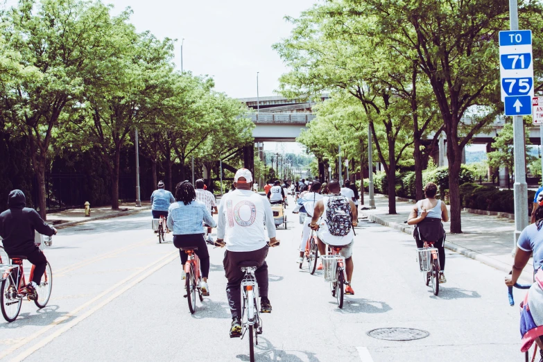 a group of people riding bikes down a street, by Washington Allston, pexels contest winner, 🚿🗝📝