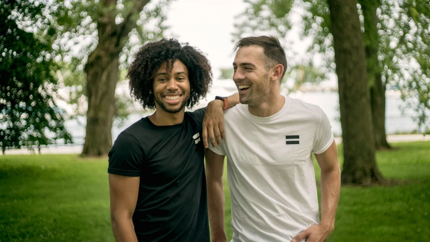 two men standing next to each other in a park, a photo, federation clothing, cheeky smile, black, avatar image