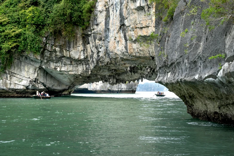 a group of people on a boat in a body of water, a picture, rock arches, hoang lap, green waters, thumbnail