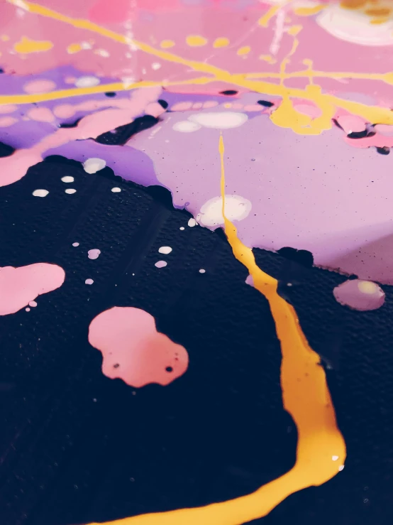 a cake sitting on top of a table covered in icing, inspired by Shōzō Shimamoto, trending on unsplash, action painting, purple and yellow, black paint drops, lo-fi art, super close up shot