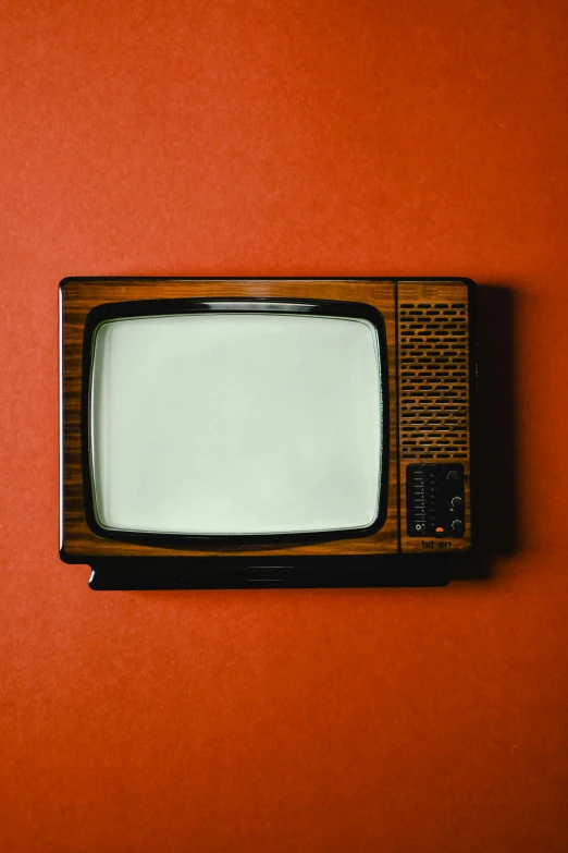 an old television sitting on top of a red surface