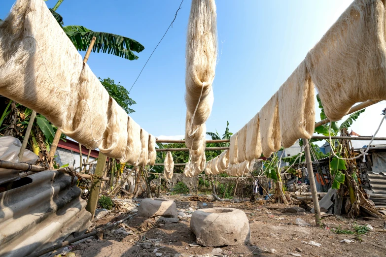 a bunch of cloth hanging from a clothes line, unsplash, gutai group, dried palmtrees, slide show, indonesia, hemp