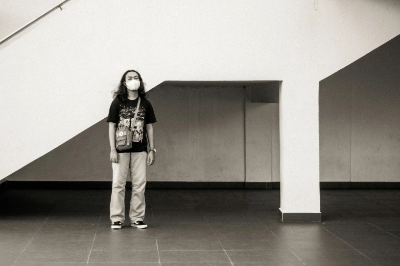 a woman standing in front of a set of stairs, a black and white photo, inspired by Thomas Struth, hyperrealism, young boy, in a mall, masked person in corner, confident stance