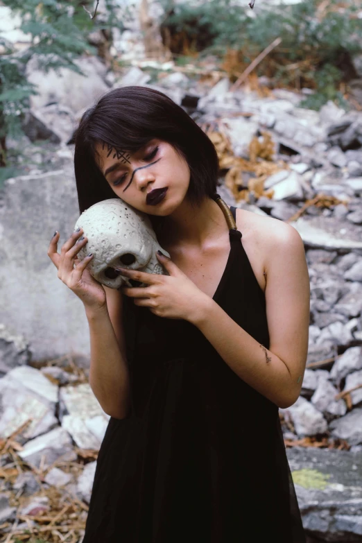 a woman in a black dress holding a skull, inspired by Taro Yamamoto, pexels contest winner, asian girl, with grey skin, ruins, 90s photo