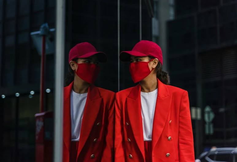 two people standing next to each other wearing face masks, by Nina Hamnett, pexels contest winner, red suit, mirrored, a suited man in a hat, she is wearing streetwear