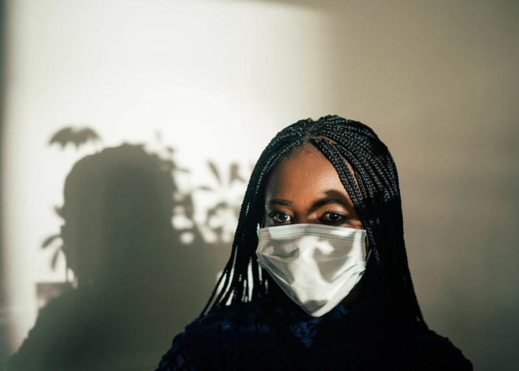 a woman wearing a face mask in a dark room, pexels contest winner, afrofuturism, full morning sun, on a gray background, healthcare worker, black teenage girl