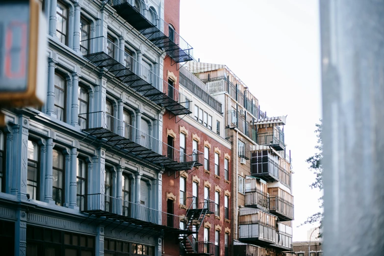 a city street filled with lots of tall buildings, a photo, pexels, renaissance, fire escapes, ignant, fine art print, brick building