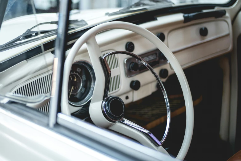 a close up of a steering wheel in a car, by Daniel Lieske, unsplash, beetle-inspired, cream and white color scheme, vintage - w 1 0 2 4, 🦩🪐🐞👩🏻🦳