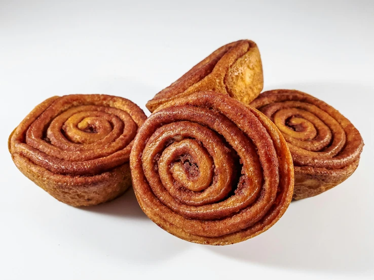 three cinnamon buns stacked on top of each other, a portrait, trending on pexels, hurufiyya, hand carved brown resin, 3/4 front view, 6 pack, ancient swirls