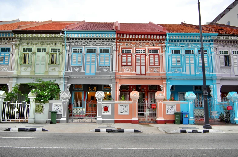 a row of colorful buildings on a city street, by Jessie Algie, pexels contest winner, set on singaporean aesthetic, richly decorated victorian house, typical, south east asian with long