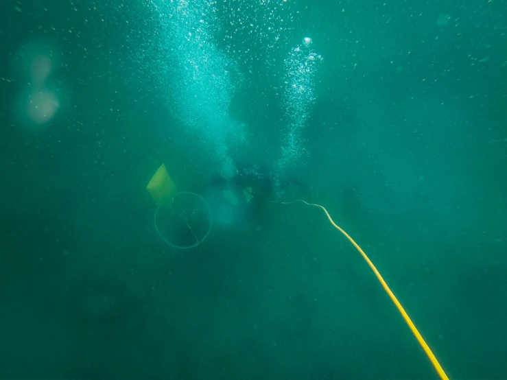 a couple of people that are in the water, bottom of ocean, deep shafts, hazy, digging