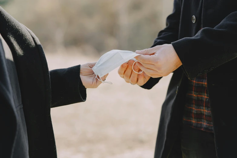 a close up of a person handing something to another person, pexels contest winner, romanticism, white ribbon, covid, well - dressed, heath clifford